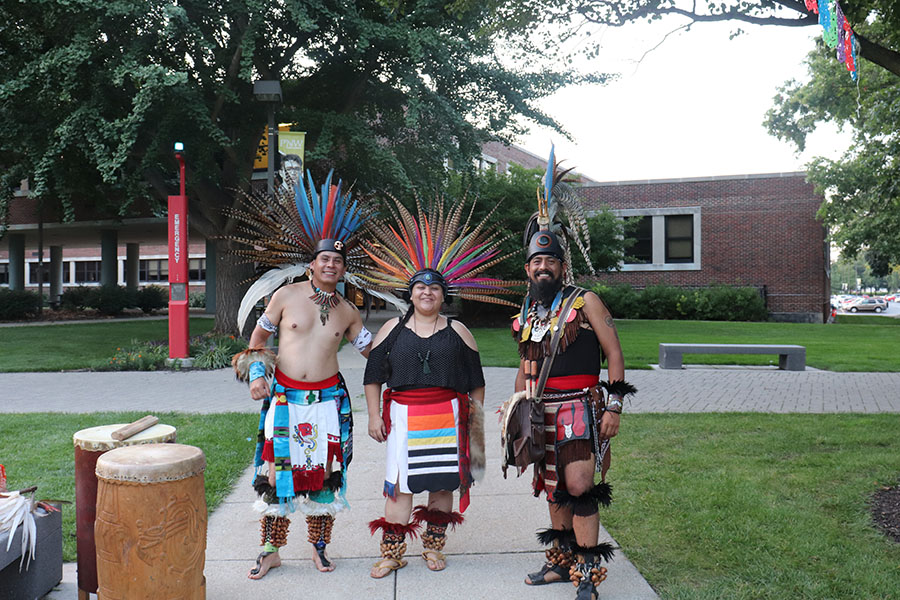 Three performers stand together in traditional Mexican outfits