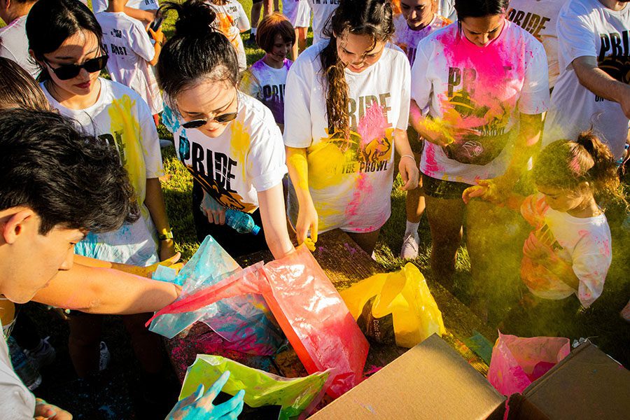 Students reach into bags of color powder placed on a table