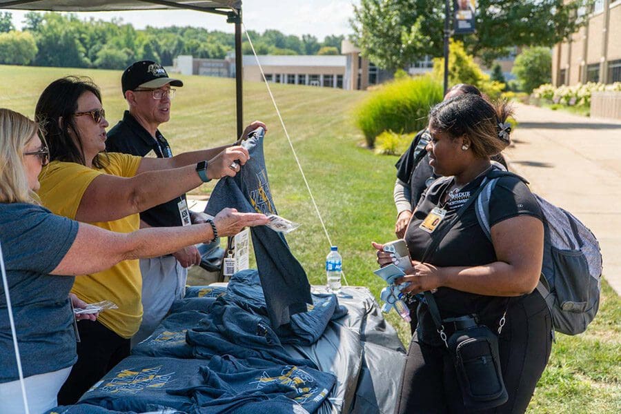 Student stands at the t-shirt tent