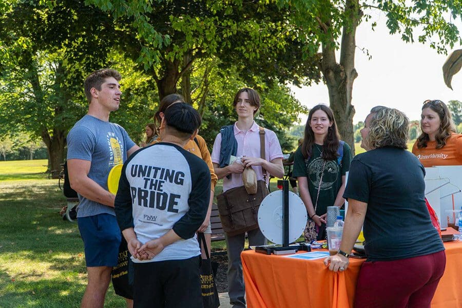 People gather around an orange table