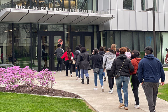 A group of potential students walk toward the Nils K. Nelson Bioscience building