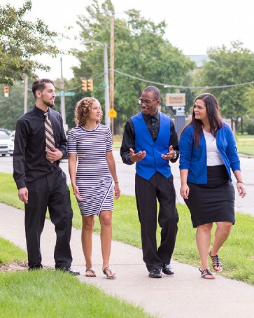 Students in dress clothes cross campus