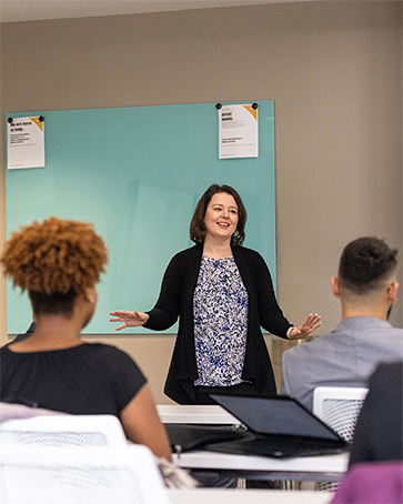 A professor speaking in front of a classroom of people