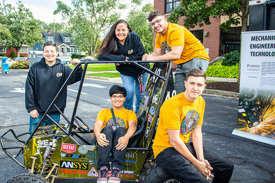 PNW's Baja students pose around their car at the Hispanic Heritage Festival