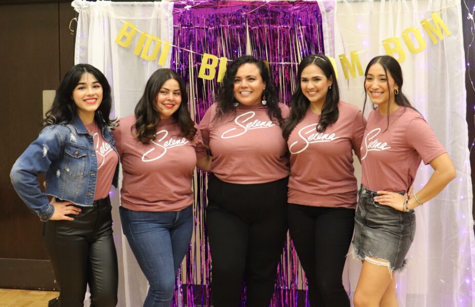 Five women stand together in matching pink shirts that read "Selenas"