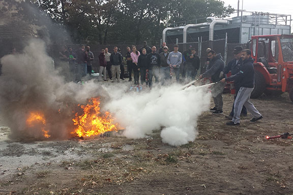 Students put out a fire during a fire safety course