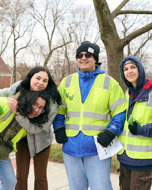 Four Honors College students pose in yellow, reflective work vests