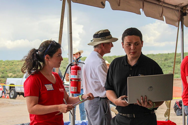 A PNW Baja member checks laptop at competition