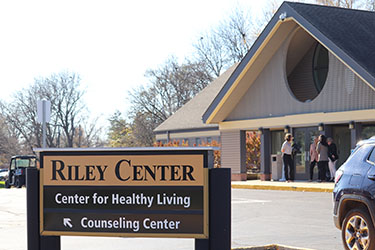A sign and building exterior for the Riley Center/Center for Healthy Living at Purdue University Northwest.