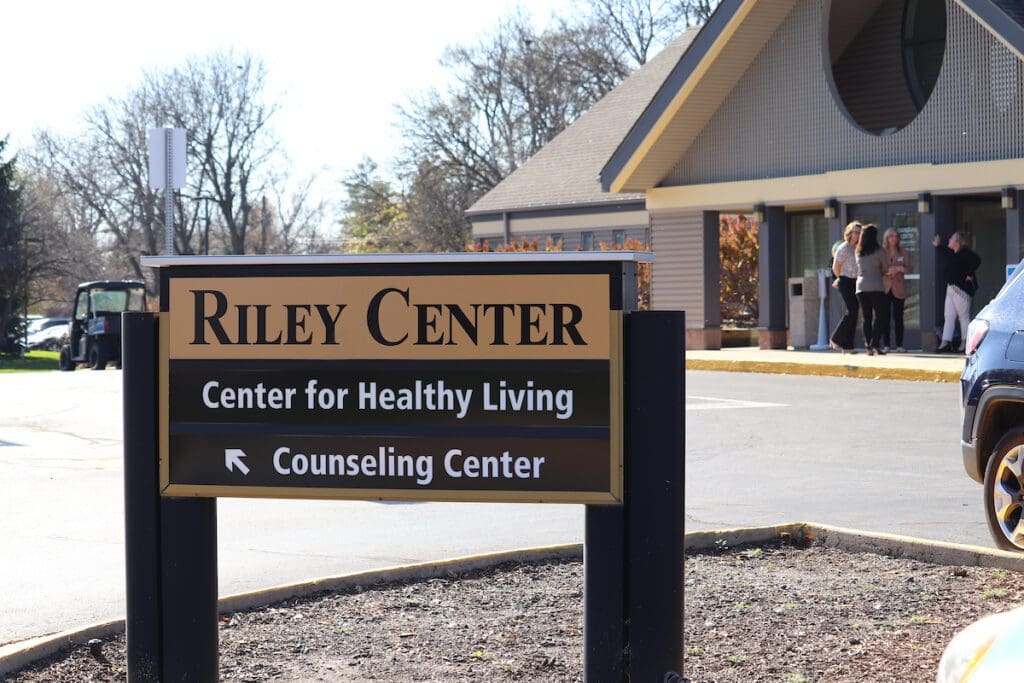 A sign in a parking lot that reads "Riley Center," with "Center for Healthy Living" and "Counseling Center" listed below
