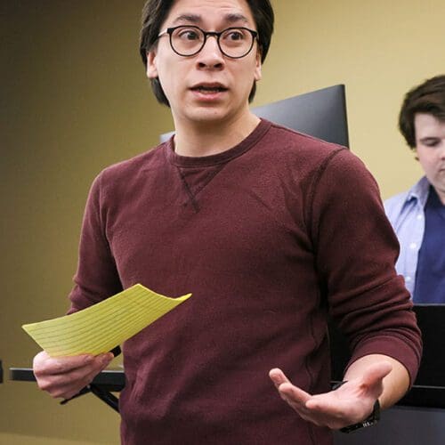 A PNW student speaks while holding a piece of paper