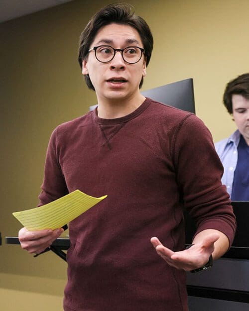 A PNW student speaks while holding a piece of paper