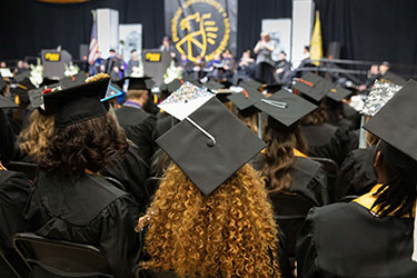 PNW graduates in their regalia at commencement.