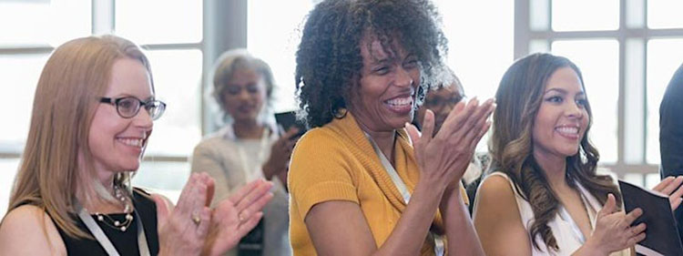 Women applaud in an audience