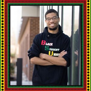 PNW student David Bolton stands on campus wearing a Black Student Union t-shirt. A white PNW logo on a black background. There is a red, yellow, and green traditional African-style border around the image.