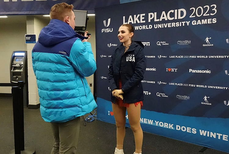 Finley Hawk is interviewed in front of a backdrop filled with sponsors.