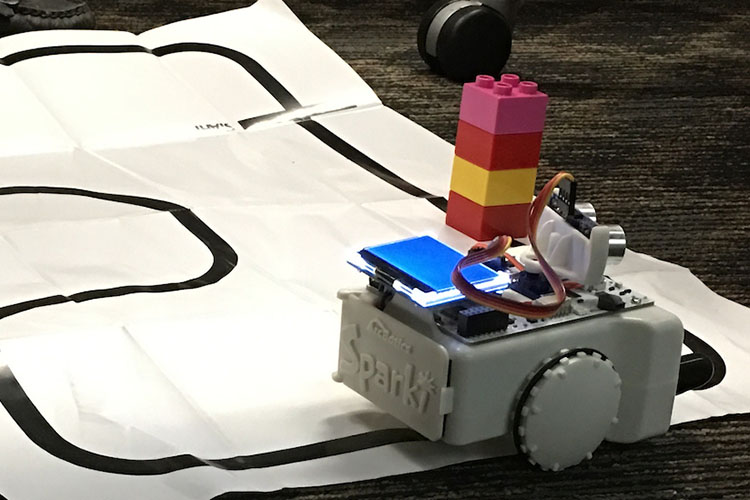 A robot on a piece of paper with a path printed on it.