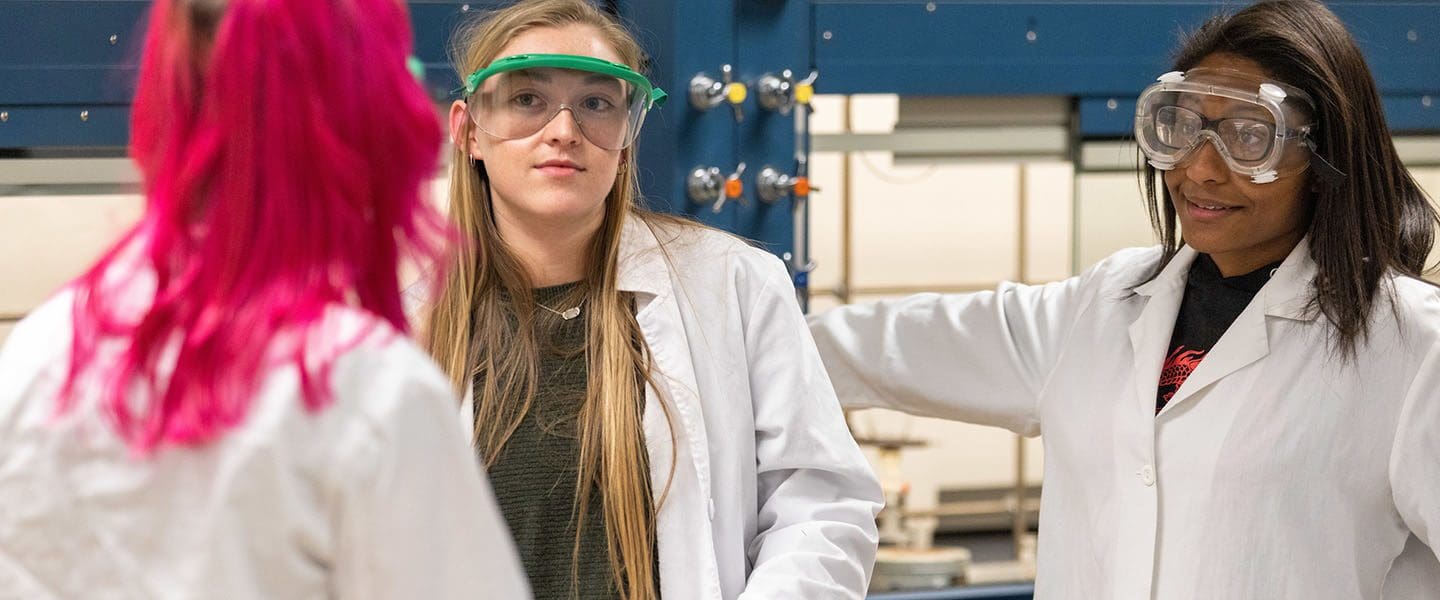 Students in PPE and lab coats