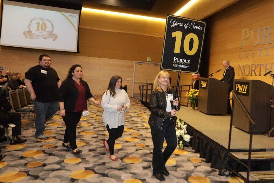 PNW staff and faculty who have completed ten years of service walk out in line.