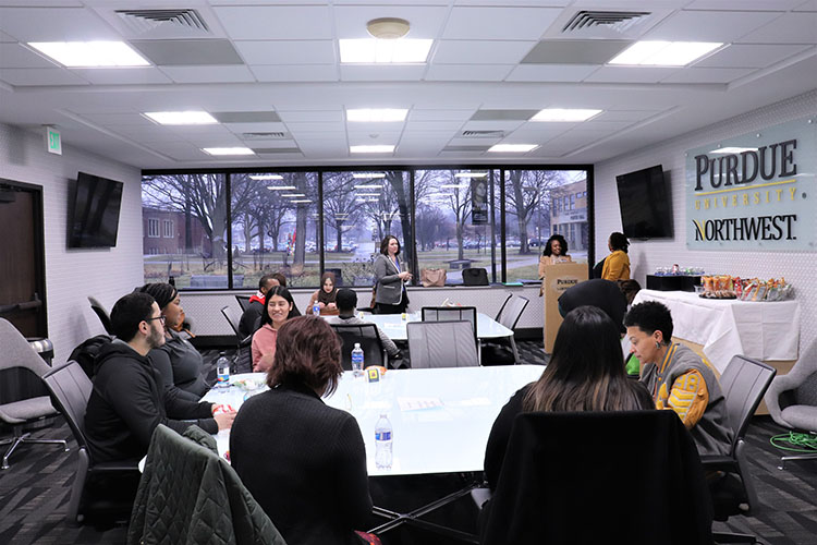 People sit around tables in a large room.