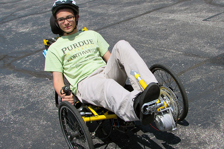 A PNW camp participant in a bike helmet rides an electric bicycle.