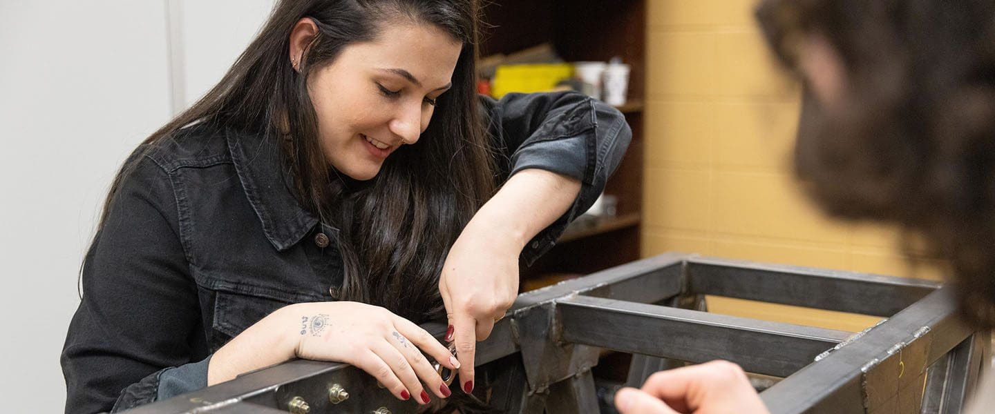 Engineering students work on a simulated steel bridge