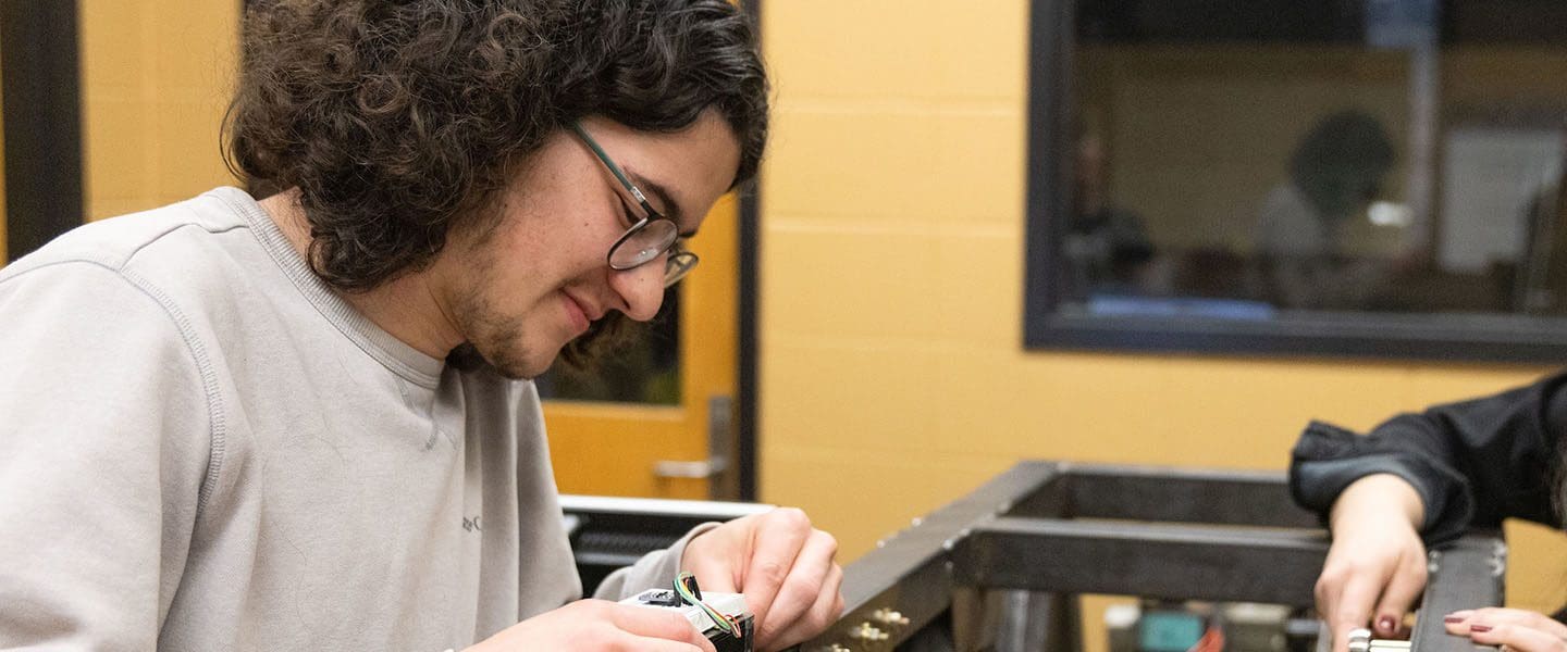 Engineering students work on a simulated steel bridge