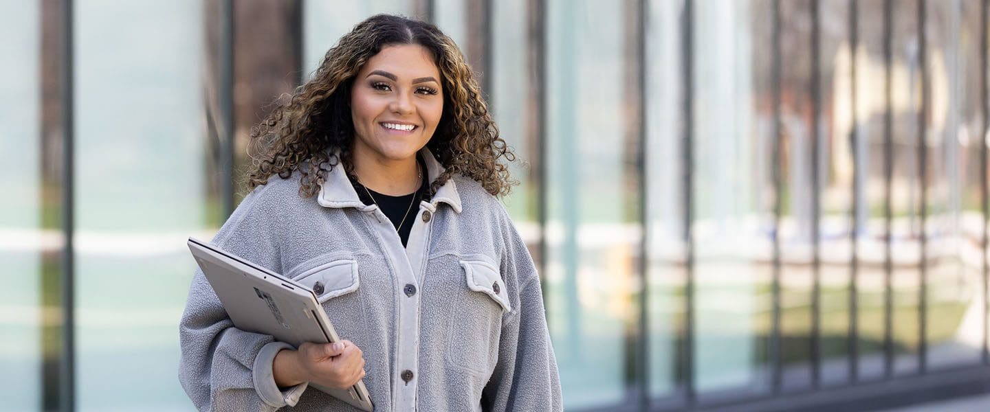 A PNW student holding her laptop outdoors