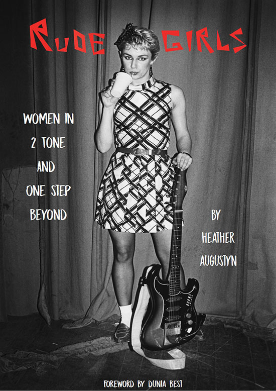 Book Cover: A woman stands, leaning against a guitar that she is holding in her left hand while drinking out of a cup with a straw in the left hand. The color is in black and white with red text on the top that reads "Rude Girls"