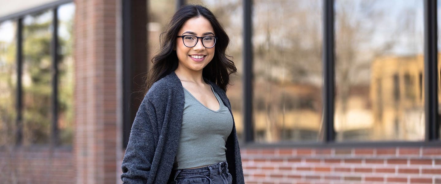 A PNW student stands outdoors