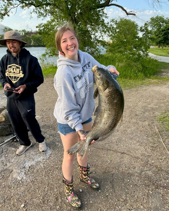 A PNW student holding a fish she has caught