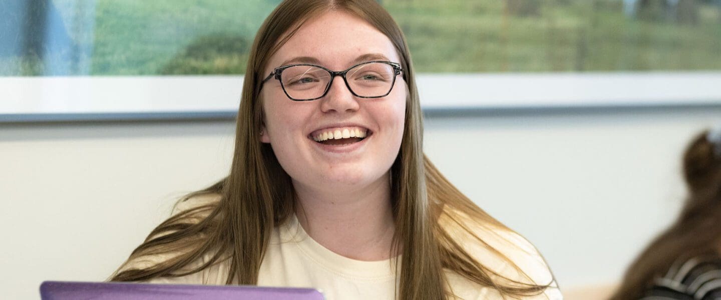 A PNW student laughs in a conference room