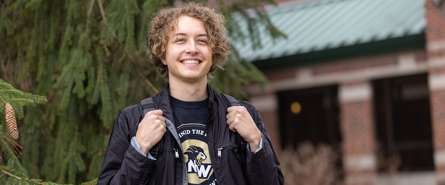 A PNW student stands outdoors