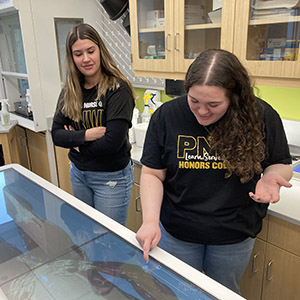 Two students work with an anatomage table