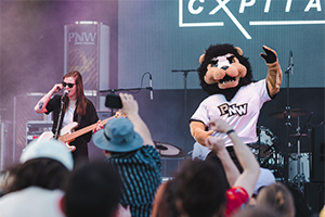 Cxpital singer Lucie Ashmore (MA ’21, BA ’19) is joined on stage by mascot Leo during Roaring Loud.