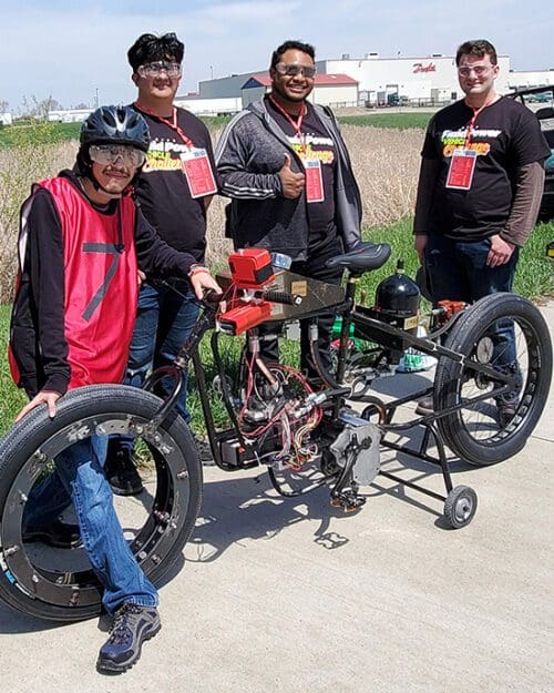 PNW Hydraulic Bike Team members Enoc Gutierrez, Diego Jimenez, Sam Torres, and Adam Hayman display their entry in the NFPA Fluid Power Vehicle Challenge..