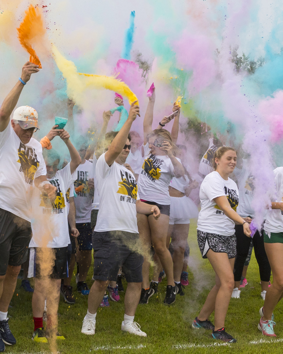 Runners throw colored powder at the PNW Pride Stride