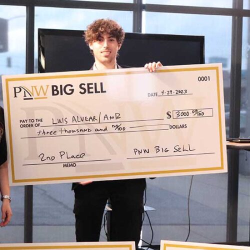 A Big Sell winner stands with a prize check