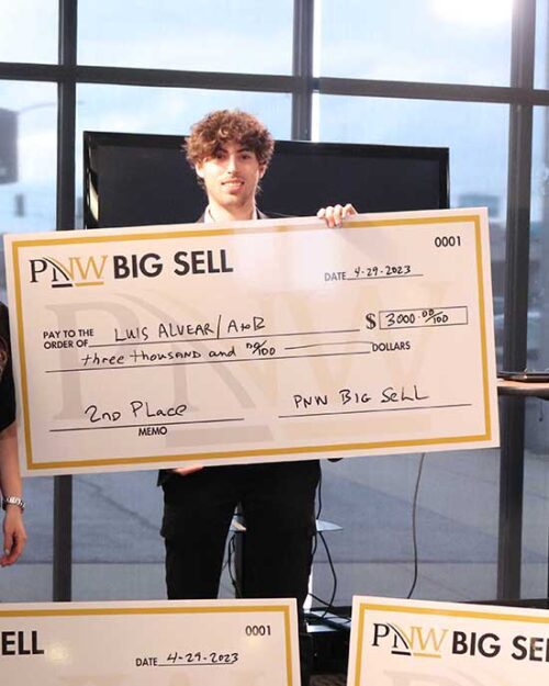 A Big Sell winner stands with a prize check