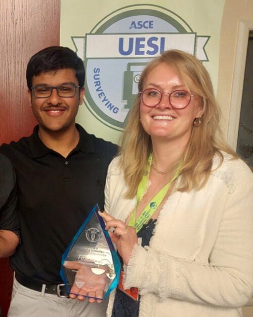 Two students pose with a trophy