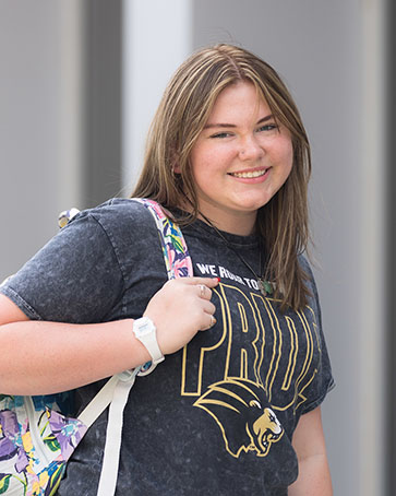 A PNW student poses with her backpack.