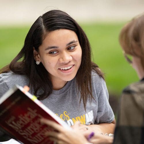 A PNW student reads a textbook outdoors