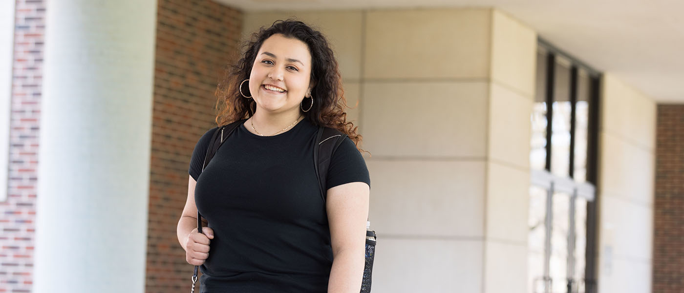 A PNW psychology student stands outdoors.