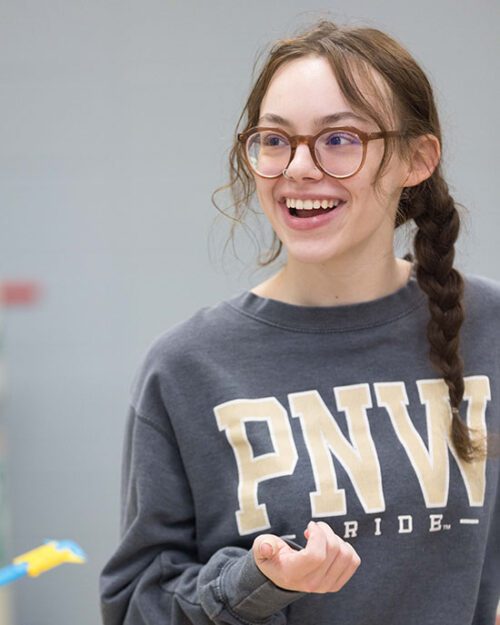 a student smiles while wearing a PNW sweatshirt