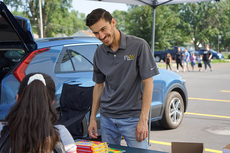 A PNW employee distributes school supplies