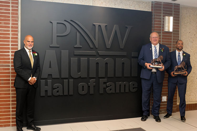2023 PNW Hall of Fame Inductees Al Sori, Stu McMillan and Robert Johnson III pose in front of the PNW Alumni Hall of Fame graphic