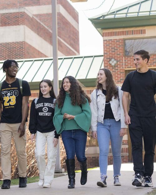 Five students walk together outdoors