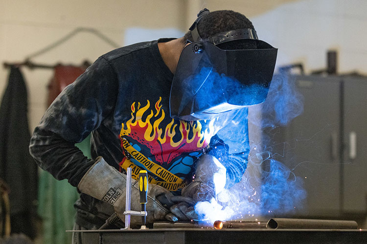 A PNW student welds metal.