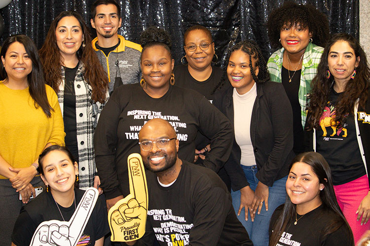 Faculty and staff gather for a photo, donning promotional shirts for the first-generation scholar's celebration.