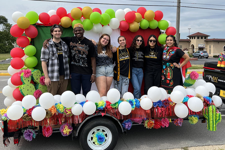 Seven honors college students stand on their float